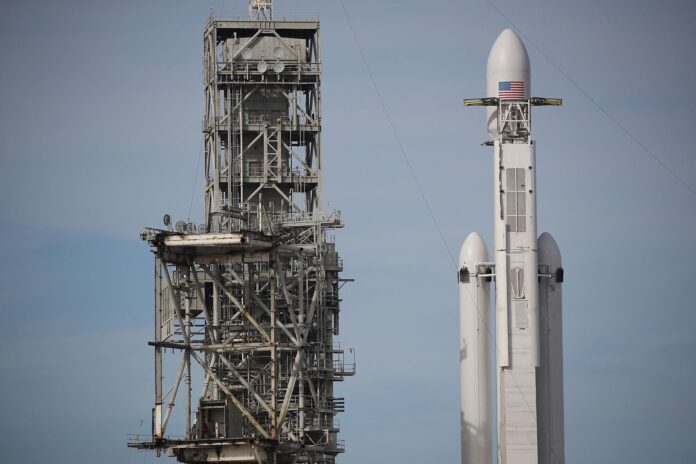 SpaceX Falcon Heavy rocket vertical on Launch Pad 39A at Kennedy Space Center, Florida, representing heavy-lift aerospace infrastructure and the foundations of space capital and aerospace economics.